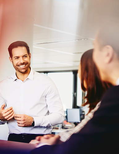 Business men and women in an office having a meeting.