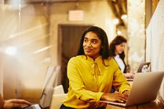 Woman working on her laptop while having a conversation