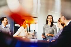 Business men and women in an office having a meeting.
