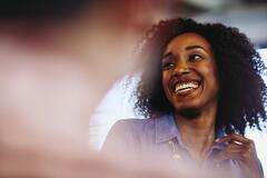 Woman smiling and talking to a someone off the picture