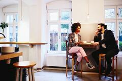 Woman and man sitting at a table with coffee. Having a conversation.