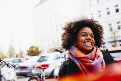 femme souriante qui se promène sur la rue