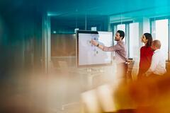 Team working on a Google Jamboard in an office.