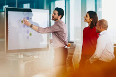 Team working on a Google Jamboard in an office.