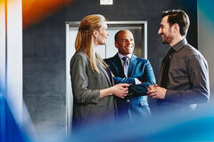 Group of people talking near an elevator.