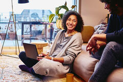 woman sitting on the floor working on a laptop