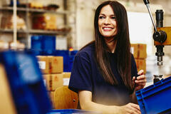 Smiling woman working on a manufacturing site.