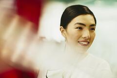 Woman smiling. China. Primary color: red.