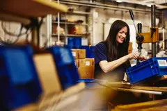 Smiling female working on a production site.
