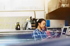 Womale operating a touch-screen display. 
