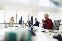 Two female and a male are working on their desk