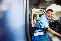 Smiling male sitting in driver's seat of a logistics truck
