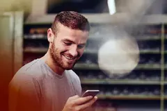 male smiling while looking at this phone.
