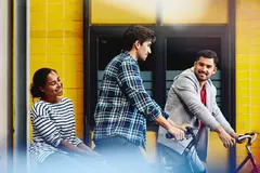 Group of colleagues (two males, one female) leaving work on bicycles. 
