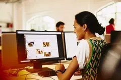 Womale sitting at a desk working on marketing platform.
