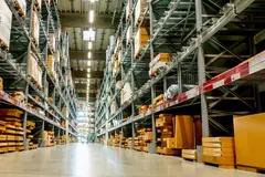 Frog view in a large warehouse in the aisle between the shelves and racks.