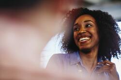 Woman smiling and talking to a someone off the picture