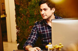 Smiling man sitting behind his desk.