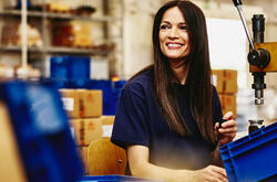 Smiling woman working on a manufacturing site.