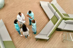Top view of a team of doctors who stand in the lobby of a modern clinic and discuss methods of treating patients.