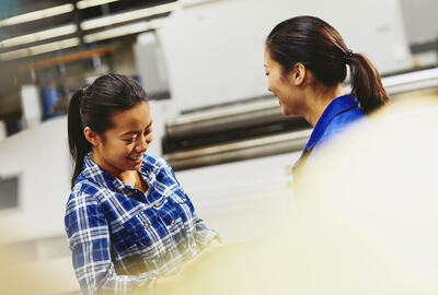 2 women talking and smiling on the workplace