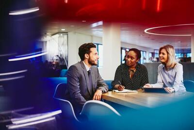 Business man and women having a meeting, smiling and taking notes in an office.