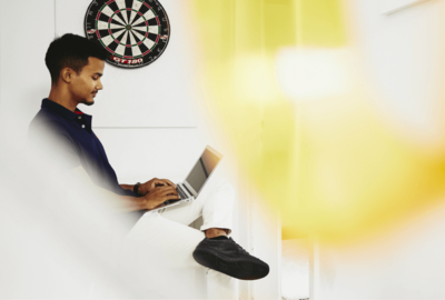 man sitting an a chair, using a laptop