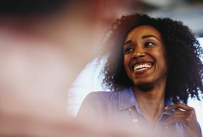 Woman smiling and talking to a someone off the picture