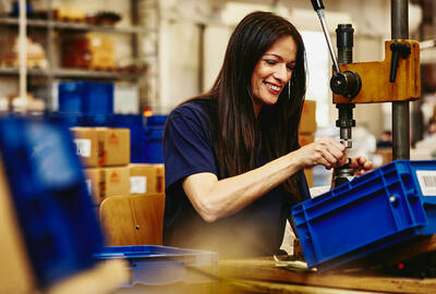 Smiling woman working on a production site.