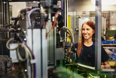 Woman operating a machine on a production site.