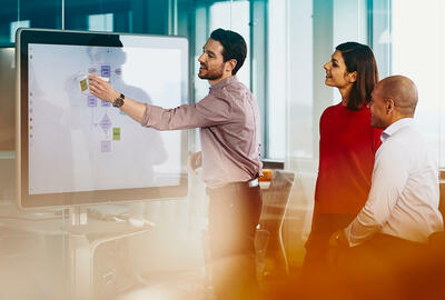 Team working on a Google Jamboard in an office.