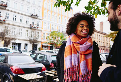 Smiling man and woman having a conversation, outside.