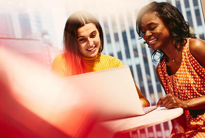 Two smiling women working together