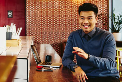 Man talking to waitress while sitting in restaurant.