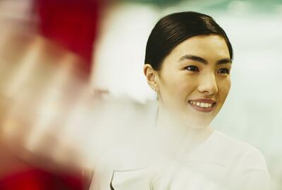 Woman smiling. China. Primary color: red.