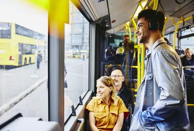 Smiling people looking outside from the bus.