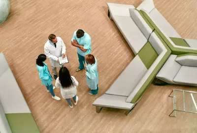Top view of a team of doctors who stand in the lobby of a modern clinic and discuss methods of treating patients.