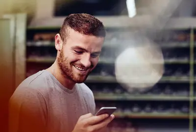 male smiling while looking at this phone.
