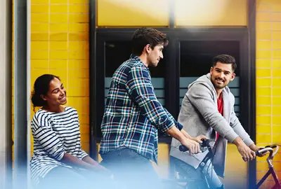 Group of colleagues (two males, one female) leaving work on bicycles. 
