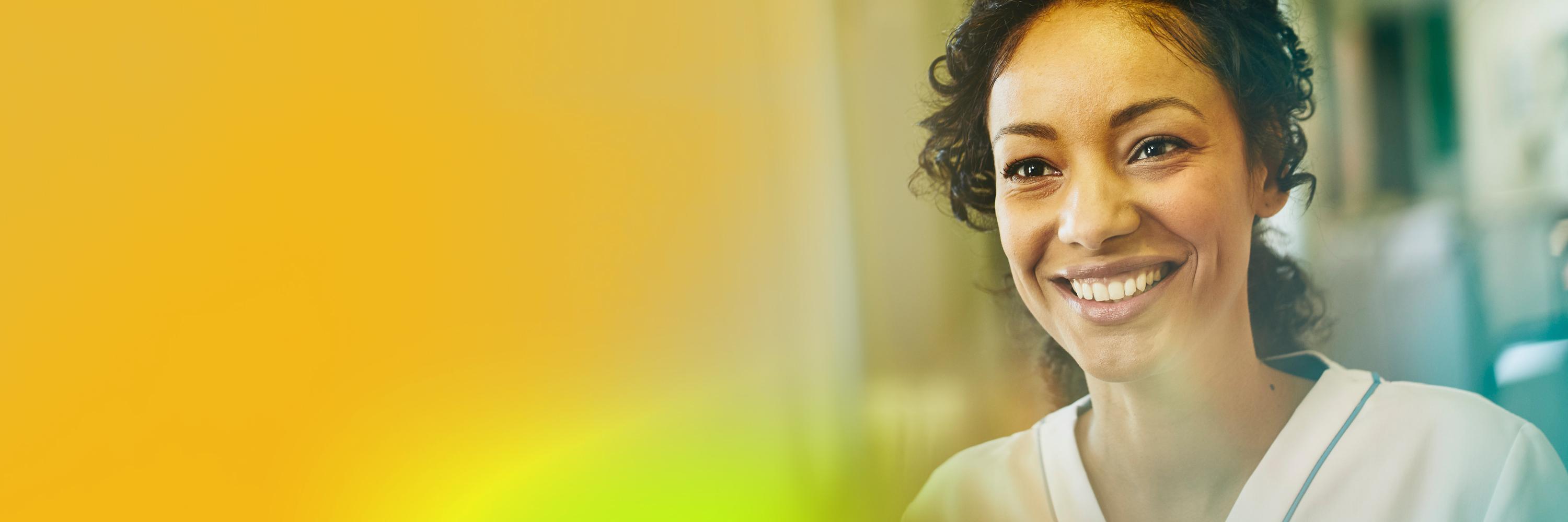 A woman healthcare professional wearing a white uniform smiling.