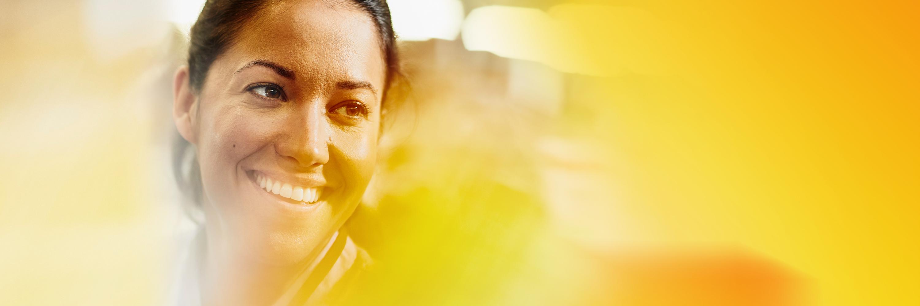 Close up - woman smiling and looking away.