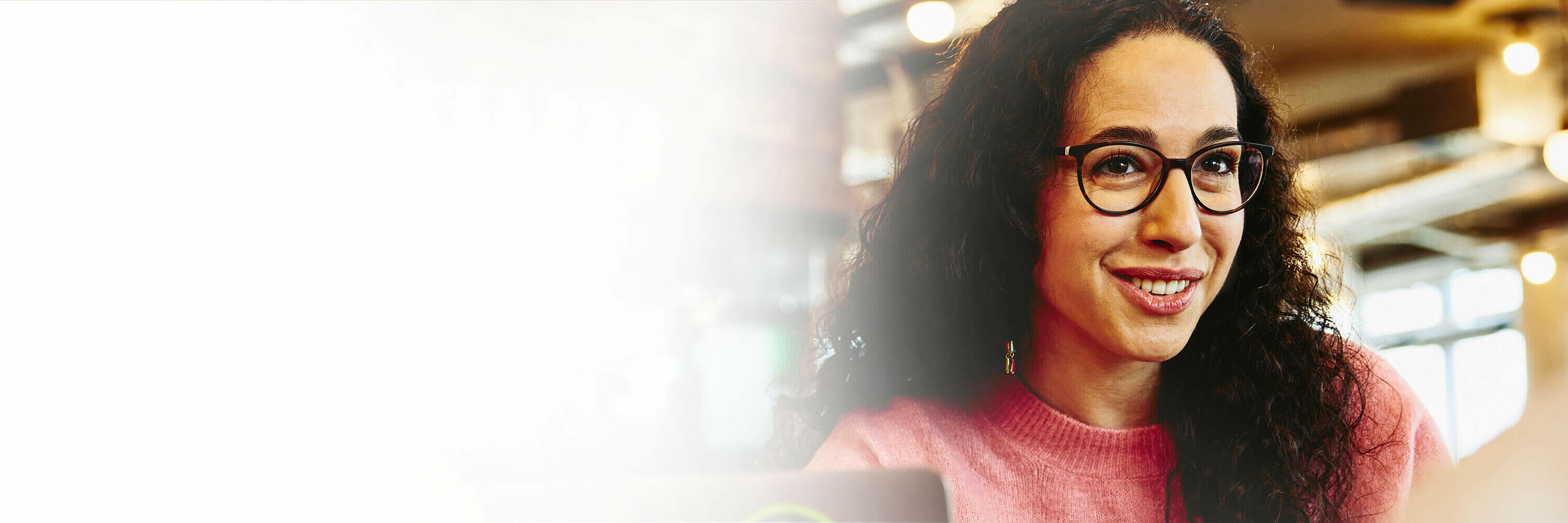 Close up - Smiling woman holding a mug while talking to someone.