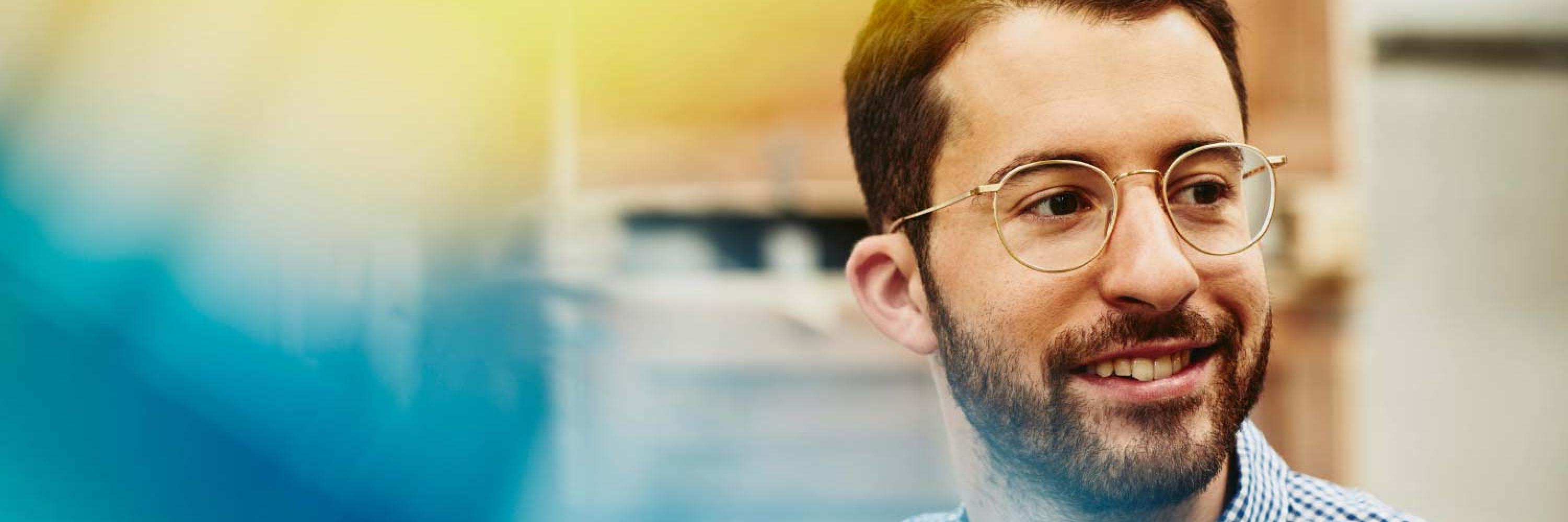 Close up - Smiling man standing in logistics environment/warehouse