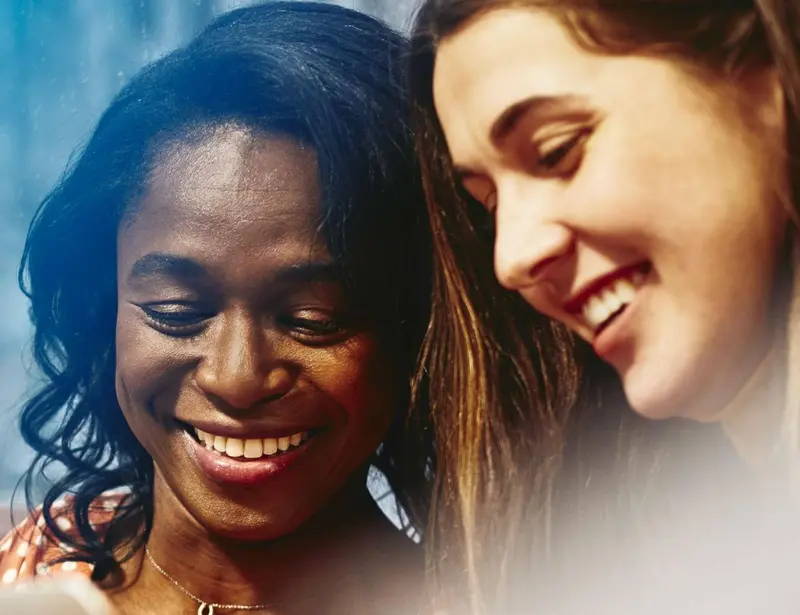 Two smiling women working together