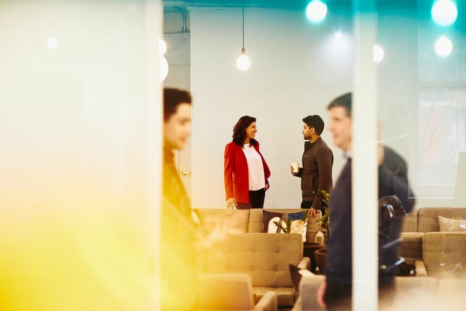 man and woman talking, coffee in hand