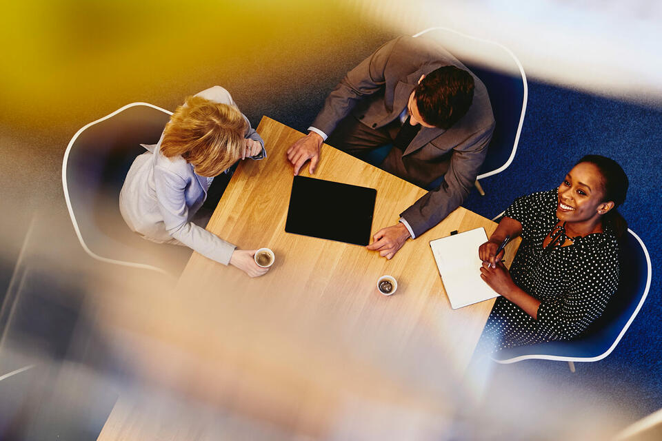 People having a meeting in an office, drinking coffee.